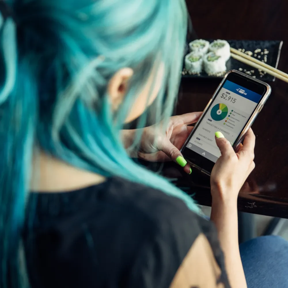 woman with colourful hair checking her bank account
