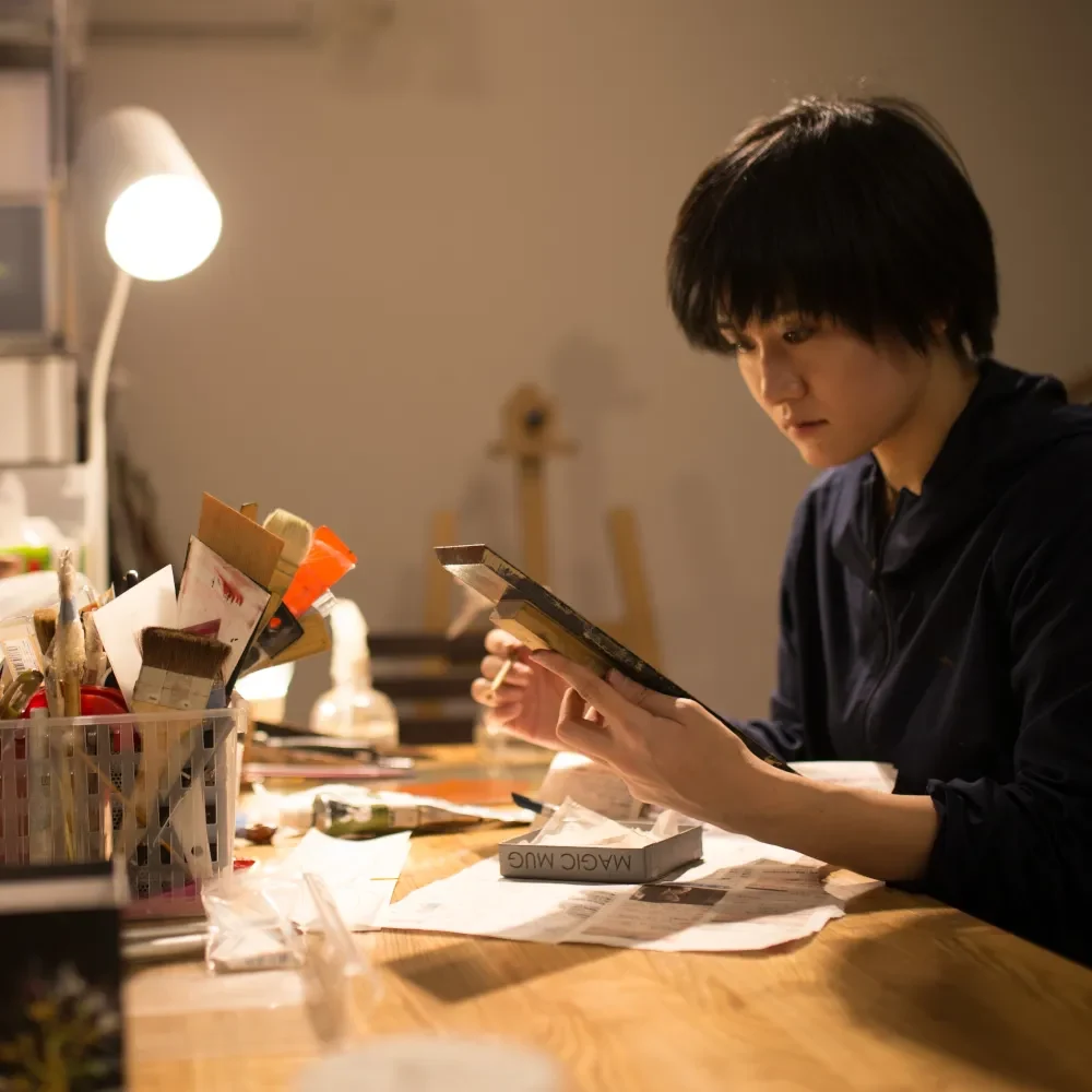 creative at a desk with paints and brushes