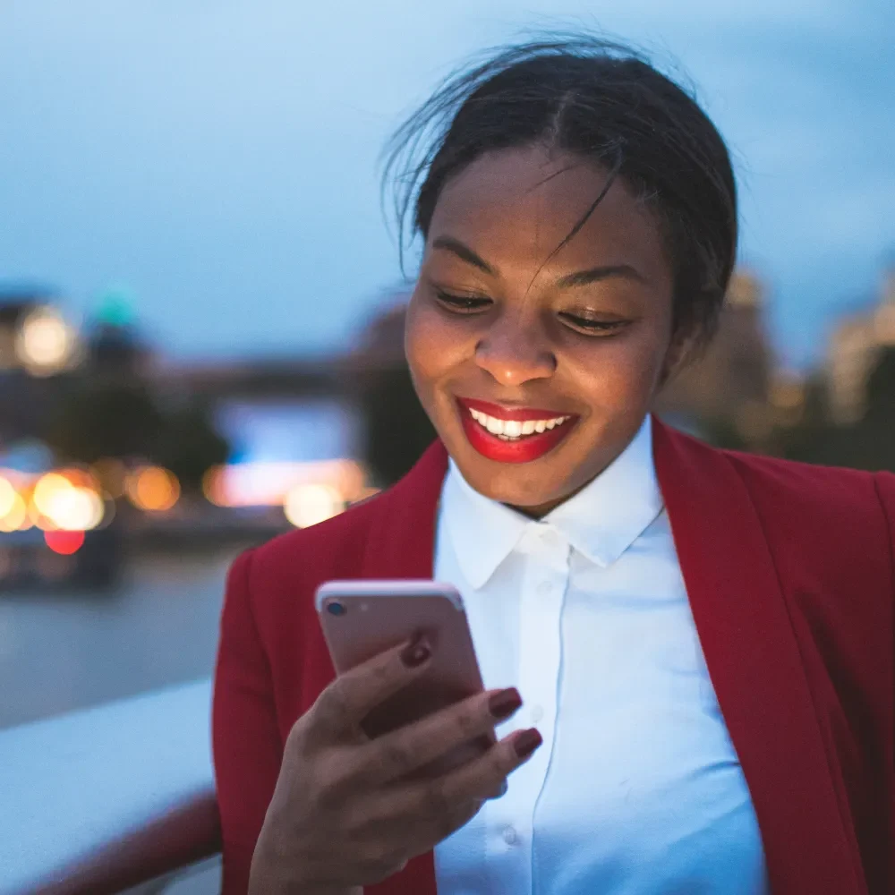 professional in a suit smiling at a message on their phone